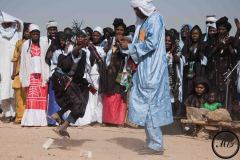 Un Touareg marque son appréciation en lançant de l'argent sur un jeune danseur, festival de l'Aïr, Iférouane, 2019.