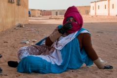 Une femme dans le camp de Boujdour. Les femmes se protègent le corps du soleil pour ne pas bronzer. Elles portent des vêtements chauds, car il est communément admis que la transpiration facilite le blanchissement de la peau. Une peau claire est un critère de beauté pour les Sahraouis.